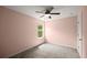 Light and airy bedroom with a window overlooking green trees and neutral carpet at 3940 Village Estates Ct, Cumming, GA 30040