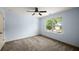 Bright blue bedroom with a ceiling fan and large window showcasing the neighborhood at 3940 Village Estates Ct, Cumming, GA 30040