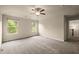 Large carpeted bedroom with ceiling fan, 2 windows, and view to hallway and stairs at 3940 Village Estates Ct, Cumming, GA 30040