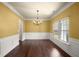 Elegant dining room with wainscoting, a modern chandelier, and natural light at 3940 Village Estates Ct, Cumming, GA 30040
