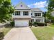 Charming two-story home featuring white siding, brick accents, and a two-car garage at 3940 Village Estates Ct, Cumming, GA 30040