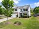Charming two-story home featuring a well-manicured lawn, attached garage, and a welcoming front porch at 3940 Village Estates Ct, Cumming, GA 30040