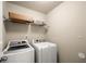 Bright laundry room featuring a white washer and dryer and storage shelf at 3940 Village Estates Ct, Cumming, GA 30040