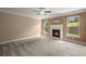 Cozy living room features a fireplace and two large windows, creating a bright and inviting atmosphere at 3940 Village Estates Ct, Cumming, GA 30040
