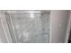 Modern bathroom shower featuring glass doors and attractive marble-patterned tile surround at 4185 Brookwood Dr, Austell, GA 30106