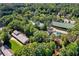 Aerial view showing a property among dense greenery with various buildings, including horse stables at 4835 Merlendale Ct, Atlanta, GA 30327