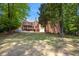 Expansive backyard with mature trees surrounding the property, and a brick exterior with screened in porch at 4835 Merlendale Ct, Atlanta, GA 30327