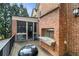 Brick home exterior with a deck featuring a grill and railings, overlooking the backyard and sunroom at 4835 Merlendale Ct, Atlanta, GA 30327