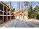 Brick home featuring three-car garage bays, with an elegant exterior design and a paved driveway at 4835 Merlendale Ct, Atlanta, GA 30327