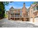 View of the home's rear exterior featuring a brick design, screened-in porch, and multiple garage doors at 4835 Merlendale Ct, Atlanta, GA 30327