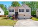 Charming split-level home featuring a well-manicured lawn, inviting front door, and attached two-car garage at 1010 Augusta Woods Dr, Douglasville, GA 30134