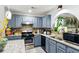 Updated kitchen featuring granite countertops, stainless steel appliances, and stylish blue cabinetry at 1010 Augusta Woods Dr, Douglasville, GA 30134