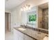 Bright bathroom featuring granite counters, double sink, soaking tub, and tiled shower at 1541 Pontiac Se Pl, Atlanta, GA 30315