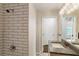 Tiled shower and sink with granite counters and modern fixtures in renovated bathroom at 1541 Pontiac Se Pl, Atlanta, GA 30315