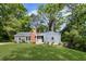 Charming blue home with a brick chimney, a lush green lawn, and mature trees against a clear blue sky at 1541 Pontiac Se Pl, Atlanta, GA 30315