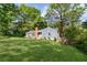 A charming blue home with a brick chimney sits surrounded by a lush, green lawn and mature trees at 1541 Pontiac Se Pl, Atlanta, GA 30315