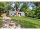 Charming blue home with a brick chimney and a spacious front yard surrounded by lush trees and a concrete driveway at 1541 Pontiac Se Pl, Atlanta, GA 30315