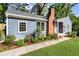 Charming blue home with a brick chimney and lush landscaping in a serene, tree-lined setting at 1541 Pontiac Se Pl, Atlanta, GA 30315