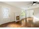 Living room featuring a decorative fireplace, hardwood floors, fresh white paint, and a modern ceiling fan at 1541 Pontiac Se Pl, Atlanta, GA 30315