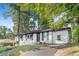 Charming home featuring a white painted brick exterior, black shutters, and a well-manicured lawn surrounded by mature trees at 2905 Gresham Se Rd, Atlanta, GA 30316