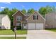 Charming two-story home featuring a stone facade, two-car garage, and well-maintained front yard at 4087 Rosebud Park Dr, Snellville, GA 30039