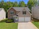 Charming two-story home with stone and vinyl siding, attached two-car garage, and manicured lawn at 4087 Rosebud Park Dr, Snellville, GA 30039