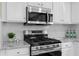 Kitchen featuring white cabinets, stainless steel appliances, and granite countertops at 4087 Rosebud Park Dr, Snellville, GA 30039