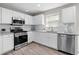 Modern kitchen featuring white cabinets, stainless steel appliances, and granite countertops at 4087 Rosebud Park Dr, Snellville, GA 30039