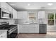 Kitchen featuring white cabinets, stainless steel appliances, and granite countertops at 4087 Rosebud Park Dr, Snellville, GA 30039