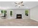 Inviting living room with a fireplace, wood flooring, and ample natural light from surrounding windows at 4087 Rosebud Park Dr, Snellville, GA 30039