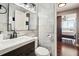 Bathroom featuring marble-look tiles, dark-wood vanity, and access to adjacent bedroom at 215 Piedmont # 1804, Atlanta, GA 30308
