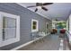 Covered porch featuring outdoor seating, ceiling fans, and views of the surrounding greenery at 2240 E Lake Ne Dr, Conyers, GA 30012