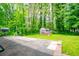 Backyard with large patio and utility shed, surrounded by lush green trees at 3047 E Anderson E Dr, Lithia Springs, GA 30122
