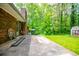 Large backyard with brick patio and utility shed, surrounded by lush green trees at 3047 E Anderson E Dr, Lithia Springs, GA 30122
