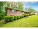 Brick home with dark shutters, lush green shrubs, and well-maintained lawn on a sunny day at 3047 E Anderson E Dr, Lithia Springs, GA 30122
