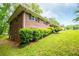 Brick home with dark shutters, lush green shrubs, and well-maintained lawn on a sunny day at 3047 E Anderson E Dr, Lithia Springs, GA 30122