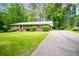 Inviting brick home with manicured bushes, green lawn, and a mature tree providing ample shade at 3047 E Anderson E Dr, Lithia Springs, GA 30122