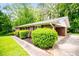 Ranch-style brick home with manicured shrubs, well-kept lawn, and covered parking at 3047 E Anderson E Dr, Lithia Springs, GA 30122