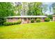 Inviting brick home with manicured landscaping, and a well-kept lawn on a sunny day at 3047 E Anderson E Dr, Lithia Springs, GA 30122