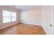 Sunlit bedroom with hardwood floors, neutral walls, and large window at 3145 Maple Terrace Drive, Suwanee, GA 30024