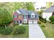 A two-story home with a brick facade, attached garage, and landscaped front yard at 3145 Maple Terrace Drive, Suwanee, GA 30024
