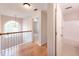 Hallway with hardwood floors, natural lighting through an arched window, and access to a bathroom at 3145 Maple Terrace Drive, Suwanee, GA 30024