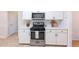Modern kitchen featuring a stainless steel gas range, white cabinetry and tile floors at 3145 Maple Terrace Drive, Suwanee, GA 30024