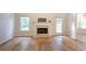 Cozy living room featuring a fireplace, hardwood floors, and natural light from multiple windows at 3145 Maple Terrace Drive, Suwanee, GA 30024
