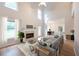 Staged living room with hardwood floors, fireplace, and soaring ceilings filled with natural light at 3145 Maple Terrace Drive, Suwanee, GA 30024