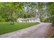 Charming single-story home with a large driveway and a well-manicured lawn at 3917 Plantation Dr, Marietta, GA 30062