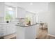 Bright, modern kitchen with white cabinets, quartz countertops, stainless steel appliances and hardwood floors at 3917 Plantation Dr, Marietta, GA 30062