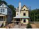 New construction of a charming three-story home with a gray chimney and dark trim windows at 11821 Serenbe Ln, Chattahoochee Hills, GA 30268