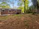 Spacious backyard with brick house, windows, trees, and foliage at 233 Banberry Se Dr, Atlanta, GA 30315