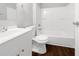 Bright bathroom with white fixtures including a vanity, toilet, and shower-tub combination at 233 Banberry Se Dr, Atlanta, GA 30315